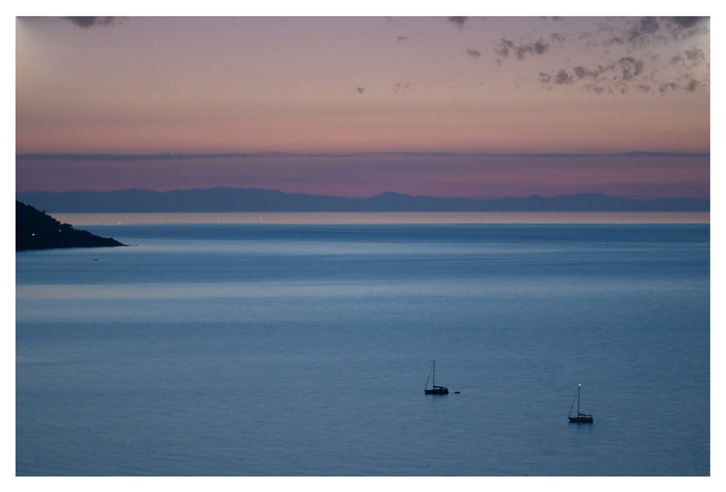 Mar en calma al atardecer en tonos rosados y azules